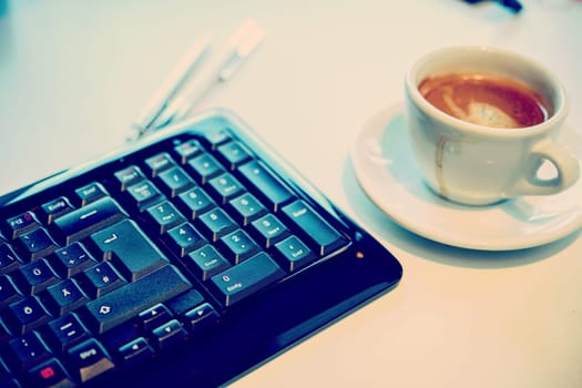cup with coffee on tesk with computer keyboard