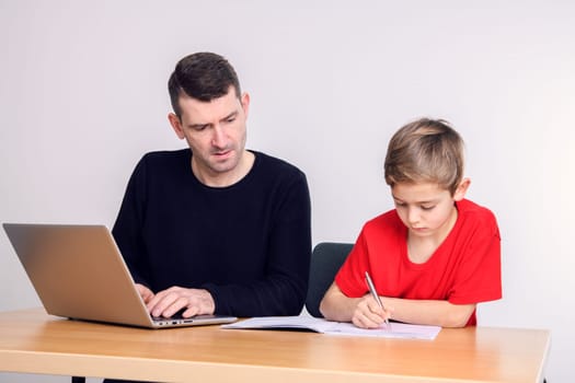 father and son using computer togetherat home