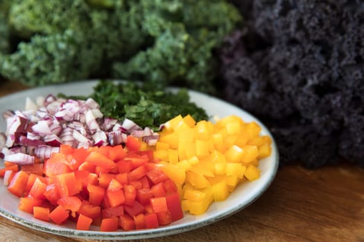 Ingredients for a healthy salad including bell peppers, onions, and kale.