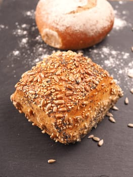Tasty organic rolls on a dark slate cutting board, natural healthy eating