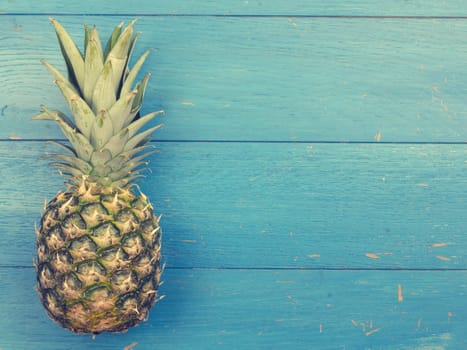Sweet organic pineapple on a blue rustic wooden background