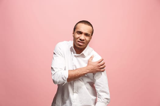 Pain concept. Beautiful male portrait isolated on pink backgroud. Young emotional surprised afro man looking at camera.Human emotions, facial expression concept. man overwhelmed with pain in shoulder
