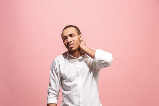 Pain concept. Beautiful male portrait isolated on pink backgroud. Young emotional surprised afro man looking at camera.Human emotions, facial expression concept. man overwhelmed with pain in neck