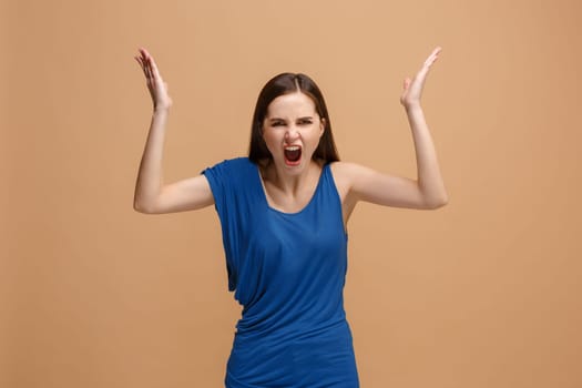 Screaming, hate, rage. Crying emotional angry woman screaming on pastel studio background. Emotional, young face. Female half-length portrait. Human emotions, facial expression concept. Trendy colors