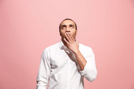 I am tired of everything. Bored man. Boring, dull, tedious concept. Young caucasian emotional afro man. Human emotions, facial expression concept. Studio shot isolated on trendy pink background