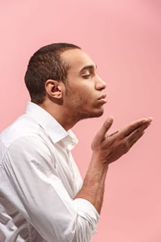 I kiss you. Portrait of attractive man with kiss on lips. Pink studio. . Profile male portrait. Young happy emotional funny afro man looking at camera. Human facial emotions concept. Trendy colors