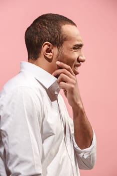 Young man is having toothache. Pain concept. Young emotional afro man. Human emotions, facial expression concept. Studio. Isolated on trendy pink color. Profile