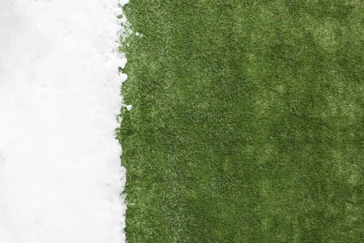 Meeting white snow and green grass close up - between winter and spring concept background. Conceptual image about spring. Selective focus. Background with copy space. Top view