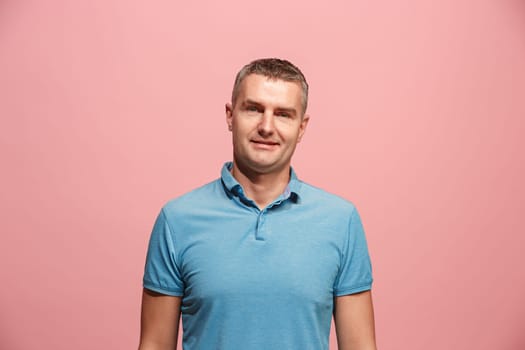 Happy business man standing and smiling isolated on pink studio background. Beautiful male half-length portrait. Young emotional man. The human emotions, facial expression concept. Front view.