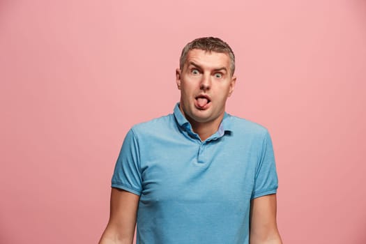 I lost my mind. The squint eyed man with weird expression. Beautiful male half-length portrait isolated on pink studio backgroud. The crazy man. The human emotions, facial expression concept.