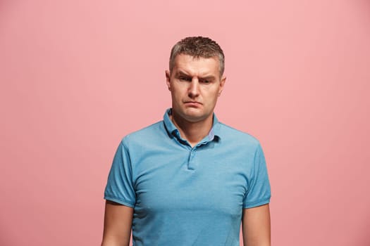 Suspicion. Doubt, mistrust, distrust concept. Doubtful man looking with disbelief expression . Young emotional man. Human emotions, facial expression concept. Studio. Isolated on trendy pink