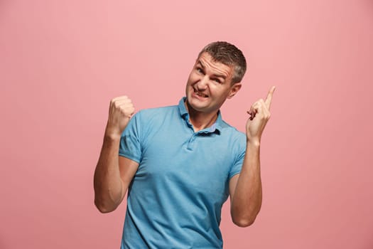 I won. Winning success happy man celebrating being a winner. Dynamic image of caucasian male model on pink studio background. Victory, delight concept. Human facial emotions concept. Trendy colors