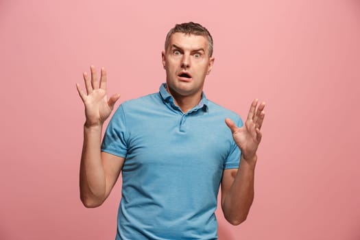 I'm afraid. Fright. Portrait of the scared man. Business man standing isolated on trendy pink studio background. male half-length portrait. Human emotions, facial expression concept. Front view