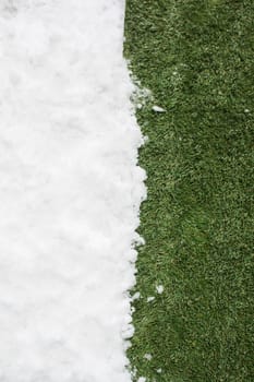 Meeting white snow and green grass close up - between winter and spring concept background. Conceptual image about spring. Selective focus. Background with copy space