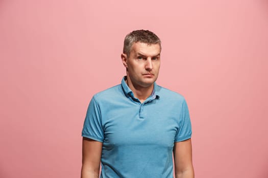 Suspicion. Doubt, mistrust, distrust concept. Doubtful man looking with disbelief expression . Young emotional man. Human emotions, facial expression concept. Studio. Isolated on trendy pink