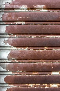 Rusty and lowered rolling shutter with parallel lines. Vintage style.