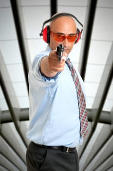 Man in shooting range with gun and goggles
