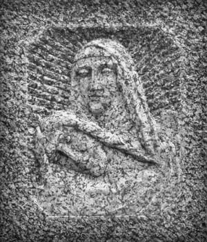 Bas-relief in stone representing The Pity of Michelangelo. Faces of Holy Mary mother and Jesus Christ after the Crucifixion.
