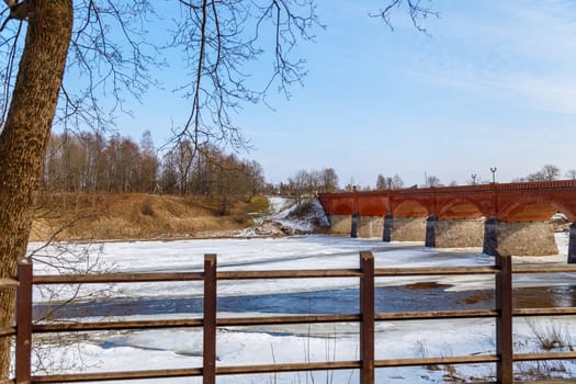 The first spring thawed patches on the river,against the backdrop of a stone bridge