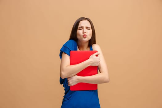 Businesswoman hugging laptop. Love to computer concept. Attractive female half-length front portrait, trendy pastel studio backgroud. Young emotional pretty woman. Human emotions, facial expression concept.