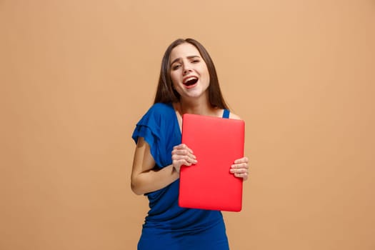 Businesswoman holding laptop. Love to computer concept. Attractive female half-length front portrait, trendy pastel studio backgroud. Young emotional pretty woman. Human emotions, facial expression concept.