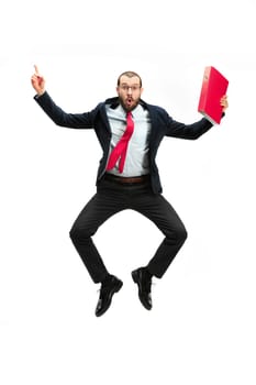 Funny cheerful businessman jumping in air over white studio background. Jump of happy bearded young man in glasses, suit. Business, career, success, win concept. Victory, delight concept. Human facial emotions