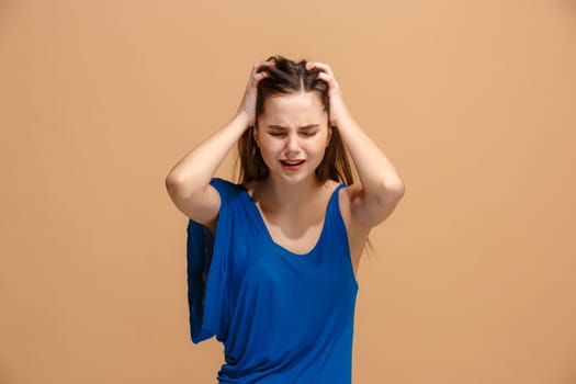 Horrible, stress, shock. Female half-length portrait isolated at pastel studio. Young emotional surprised woman clasping head in hands. Human emotions, facial expression concept. Trendy colors. Front view
