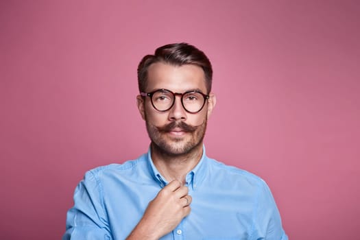Portrait of a handsome young happy man over pink astudio background