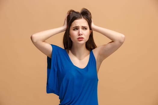 Horrible, stress, shock. Female half-length portrait isolated at pastel studio. Young emotional surprised woman clasping head in hands. Human emotions, facial expression concept. Trendy colors. Front view