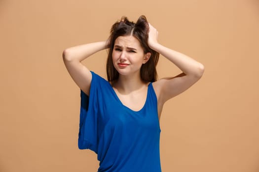Horrible, stress, shock. Female half-length portrait isolated at pastel studio. Young emotional surprised woman clasping head in hands. Human emotions, facial expression concept. Trendy colors. Front view