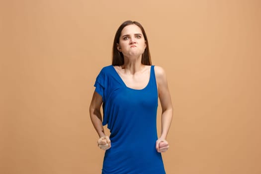 Angry woman looking at camera. Aggressive business woman standing isolated on trendy pastel studio background. Female half-length portrait. Human emotions, facial expression concept. Front view.