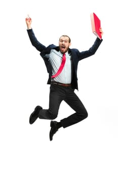 Funny cheerful businessman jumping in air over white studio background. Jump of happy bearded young man in glasses, suit. Business, career, success, win concept. Victory, delight concept. Human facial emotions