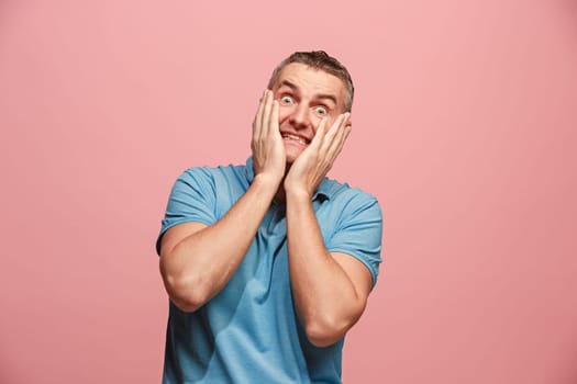 I'm afraid. Fright. Portrait of the scared man. Business man standing isolated on trendy pink studio background. male half-length portrait. Human emotions, facial expression concept. Front view