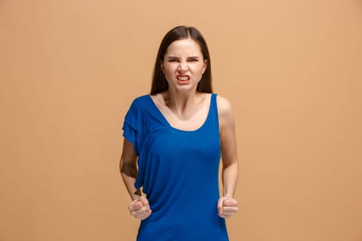 Angry woman looking at camera. Aggressive business woman standing isolated on trendy pastel studio background. Female half-length portrait. Human emotions, facial expression concept. Front view.