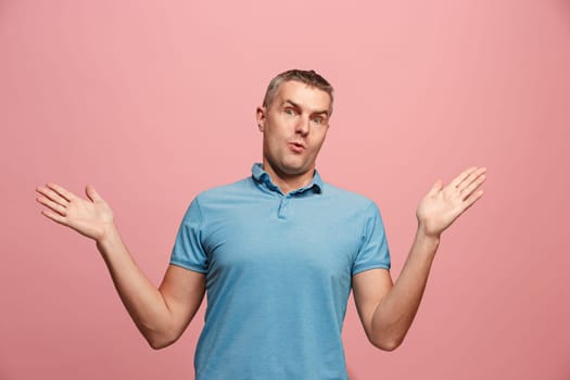Wow. Attractive male half-length front portrait on pink studio backgroud. Young emotional surprised bearded man standing with open mouth. Human emotions, facial expression concept. Trendy colors