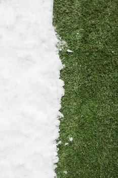 Meeting white snow and green grass close up - between winter and spring concept background. Conceptual image about spring. Selective focus. Background with copy space