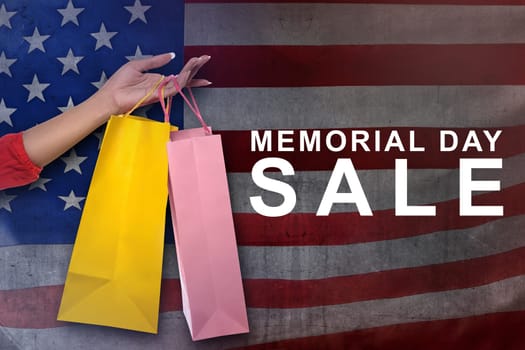 Female hand with shopping bag on memorial day sale with american flag background