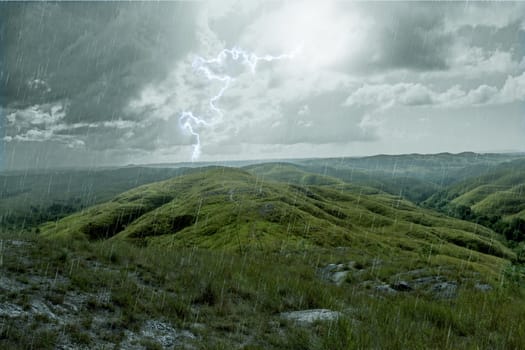 Thunder and lightnings during the rain on the green field