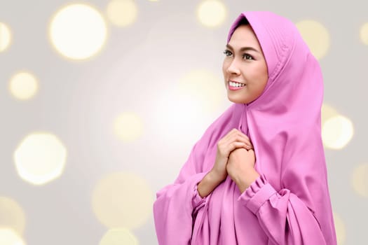 Pretty asian muslim woman with pink veil over blur light background