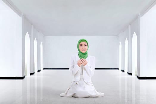 Pretty asian muslim woman praying to god in the mosque