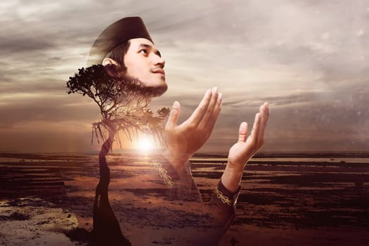 Handsome asian muslim man pray to god at sunset on the beach. Double Exposure effect