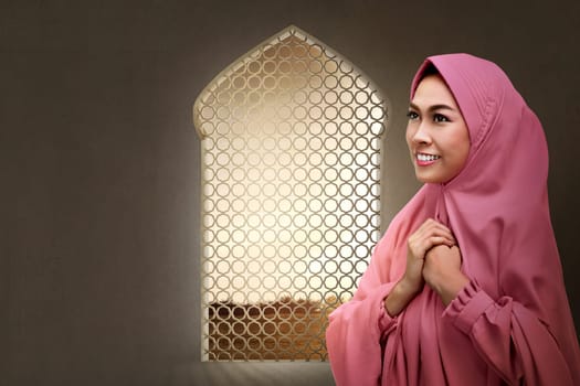 Pretty asian muslim woman praying to god in the mosque