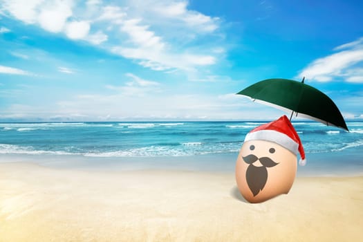 Egg with santa hat in the beach with blue ocean background