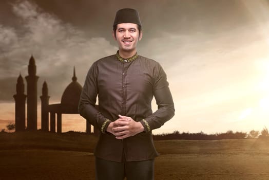 Handsome asian muslim man standing during sunset at outdoor