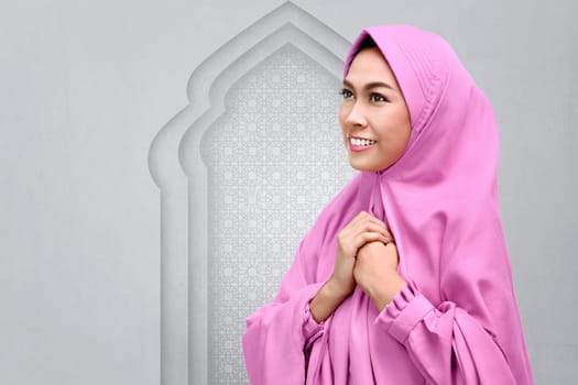 Smiling asian muslim woman pray to god on the mosque