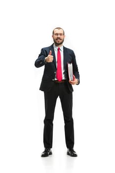 Full body or full-length portrait of businessman with red folder on white studio background. Serious bearded young man in glasses, suit, red tie standing in office. Business, career, success concept.