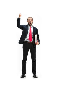Full body or full-length portrait of businessman with red folder on white studio background. Happy bearded young man in glasses, suit, red tie standing in office. Business, career, success concept.