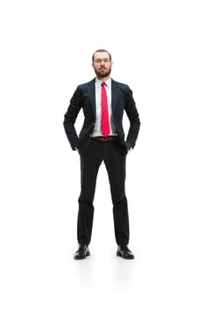 Full body or full-length portrait of businessman on white studio background. Serious bearded young man in glasses, suit, red tie standing in office. Business, career, success concept.