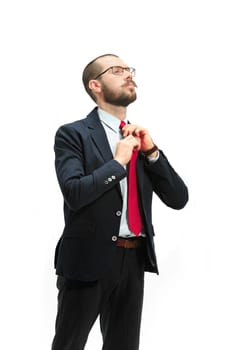 Full body or full-length portrait of businessman on white studio background. Serious bearded young man in glasses, suit, red tie standing in office. Business, career, success concept.