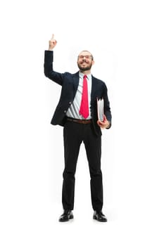 Full body or full-length portrait of businessman with red folder on white studio background. Happy bearded young man in glasses, suit, red tie standing in office. Business, career, success concept.